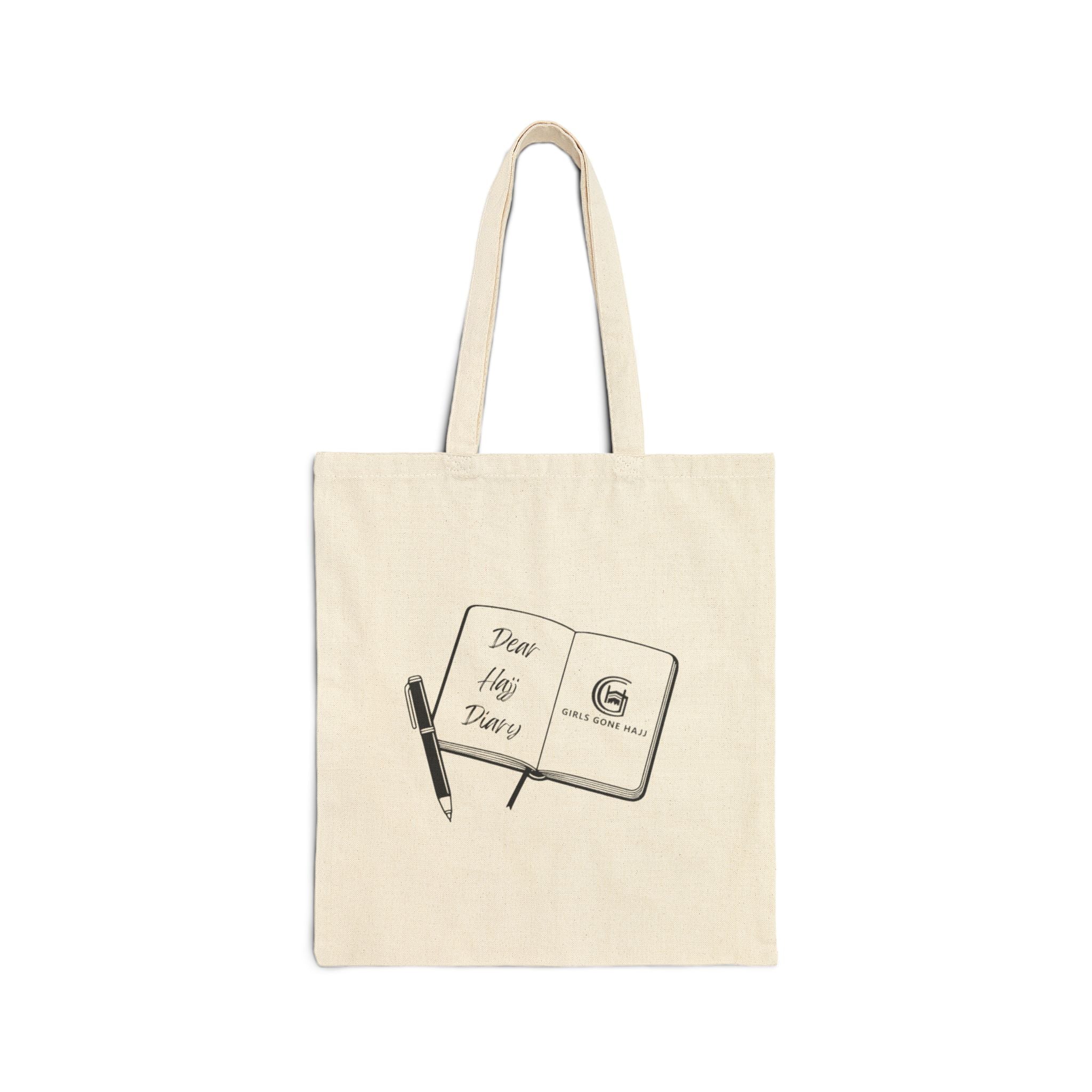 Beige tote bag with a design of an open journal and pen image on a white background.